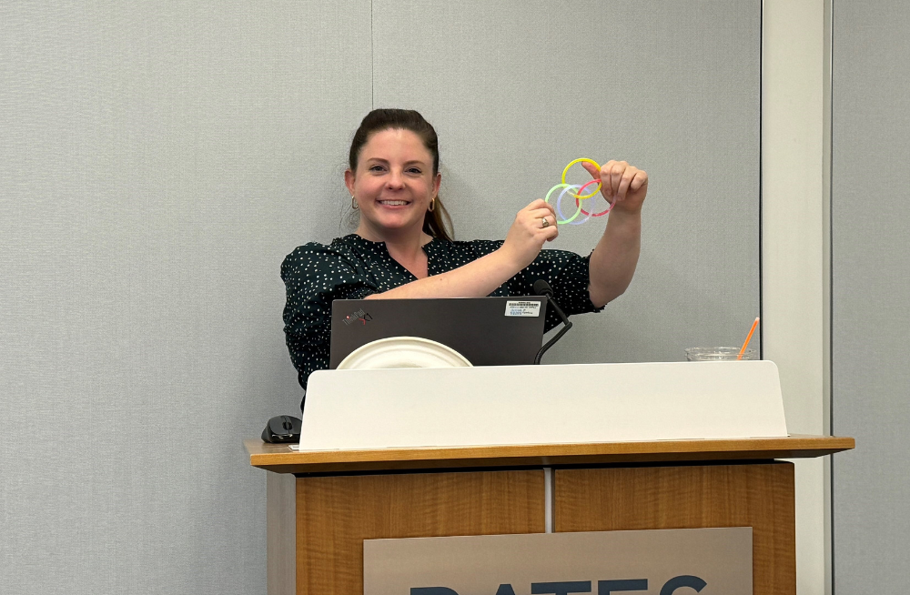 A smiling woman holds various linked rings representing a Venn Diagram.