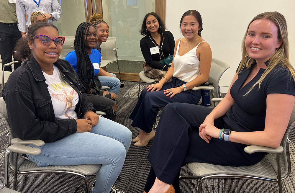 Six smiling women sitting together.