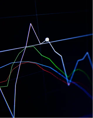 dark background chart with intersecting red, green, and blue lines showing data trends.